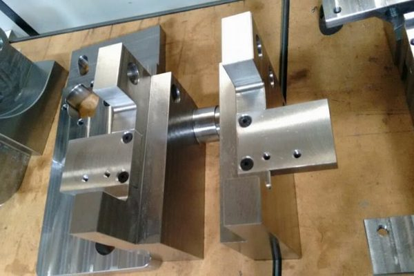 Conjunto de peças metálicas usinadas com furos, rebaixos e um eixo central